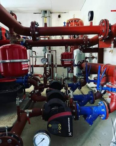 Plantroom pipework with flanged connections, pumps and valves.